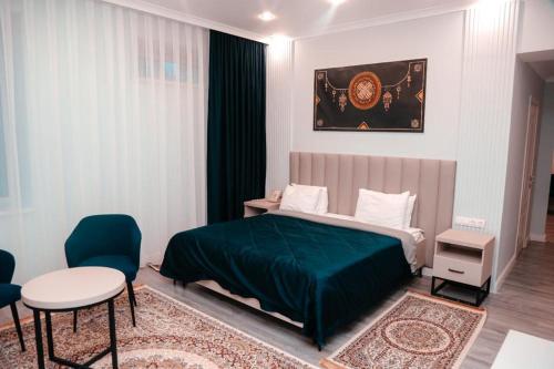 博罗沃耶Лечебно-оздоровительный комплекс Ок-Жетпес的一间卧室配有绿色的床和桌椅