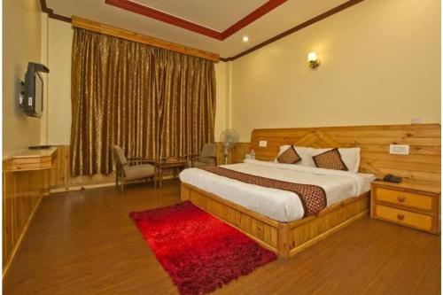 斯利那加Hotel Ocean, Shrinagar的一间卧室配有一张大床和红色地毯。