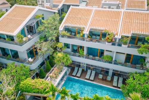 会安CHiEM HoiAn - The Beachside Boutique Hotel & Villa的享有公寓大楼空中景致,设有游泳池