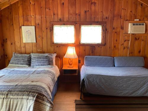 乔治湖Amber Lantern Efficiency Cottage的小木屋内一间卧室,配有两张床