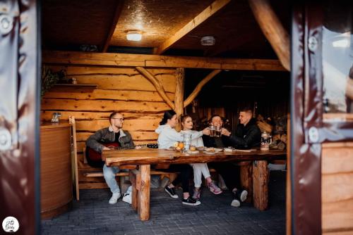 戈乌达普Apartament Pod Górką Gołdap的一群坐在餐厅桌子上的人