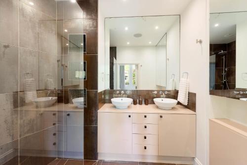 伦敦Beautiful Regents Park Apartment的一间带两个盥洗盆和淋浴的浴室