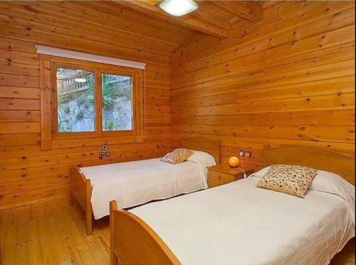 马塔罗Nordica的小木屋内一间卧室,配有两张床