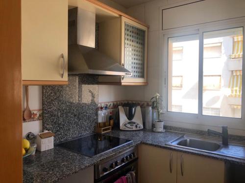 卡拉费尔Apartamento a 20 metros de la playa的厨房设有水槽和窗户。