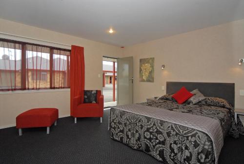 哈士汀欧玛胡汽车旅馆的一间卧室配有一张床和一张红色椅子