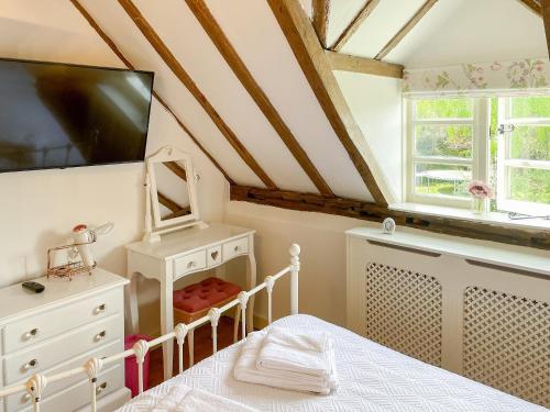 HinstockOld Church Farm的卧室配有一张床,墙上配有电视。