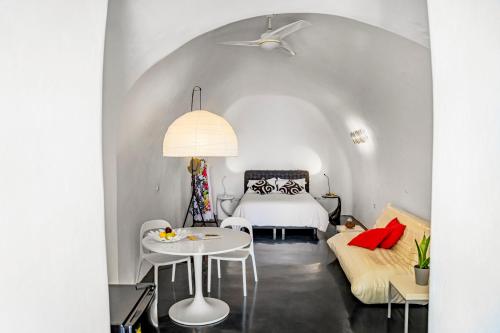 菲罗斯特法尼散斯优传统洞穴公寓的卧室配有白色的床和桌椅