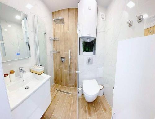 瓦尔纳Nova City Apartments的带淋浴、卫生间和盥洗盆的浴室