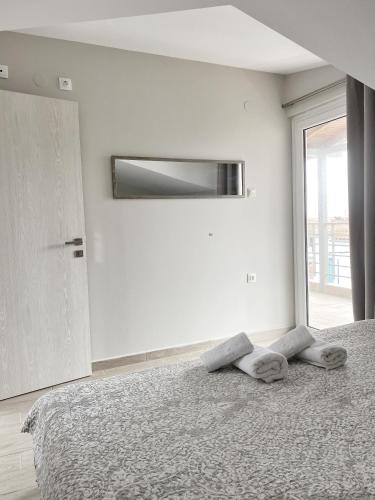 佩科霍里Delia Apartments的白色卧室设有一张带窗户的床