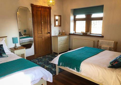 KinlossThe Tower, Moray Firth Holiday Home的一间卧室设有两张床、一个水槽和镜子