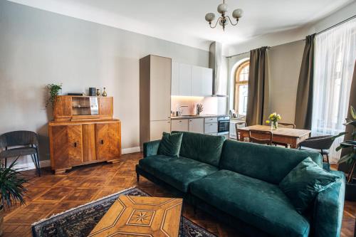 里加Constantine Apartments的一间带绿色沙发的客厅和一间厨房