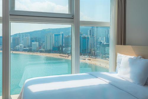 釜山Hotel Marine view的一间卧室设有大窗户,享有海滩美景
