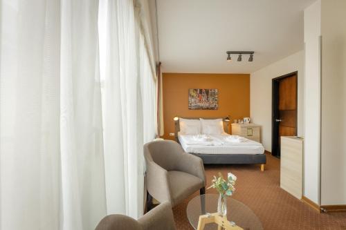 布达佩斯Bliss Residence & Spa的酒店客房配有一张床铺和一张桌子。