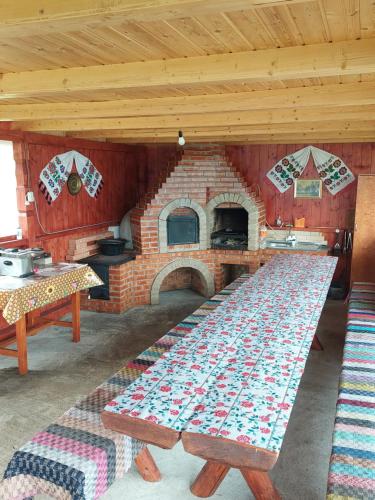 戈尔达德苏斯Cabana Gabriela的厨房配有砖炉,前面设有桌子