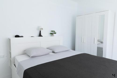 圣胡安海滩Aqua Vista Playa San Juan的白色卧室配有带2个枕头的床