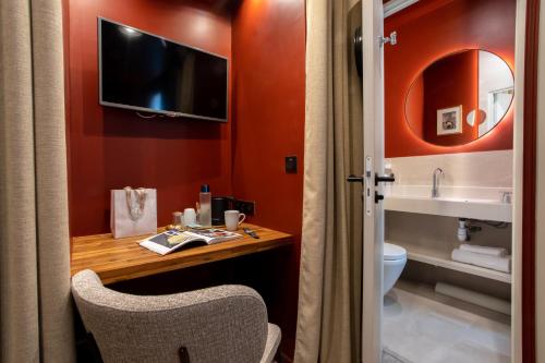 巴黎萨夏酒店的一间带书桌和卫生间的浴室以及一台电视。