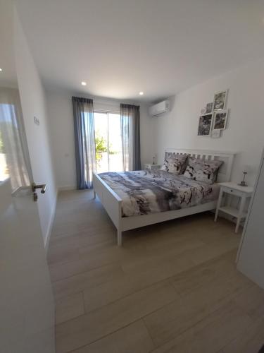 阿尔坎塔里利亚Villa Girassol met zwembad的白色的卧室设有床和窗户