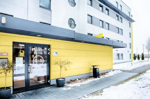 哈尔伯格摩斯B&B HOTEL München-Airport的黄色的建筑,旁边是钟