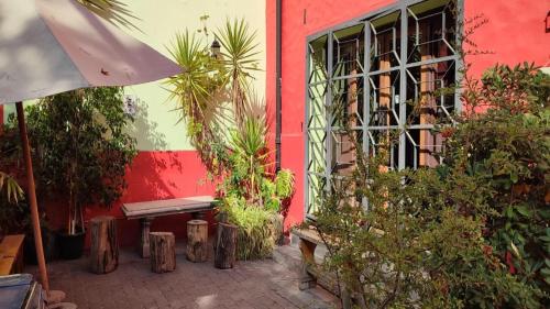 圣地亚哥阿吉青年旅社的一座红色的建筑,有长凳和一些植物