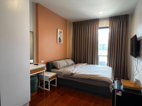 Ban YangSmile Residence at Kaset-Sena的一间卧室配有一张床、一张书桌和一个窗户。