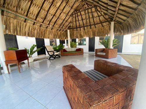 托卢Hostal El Danubio Tolu的带沙发和稻草屋顶的客厅