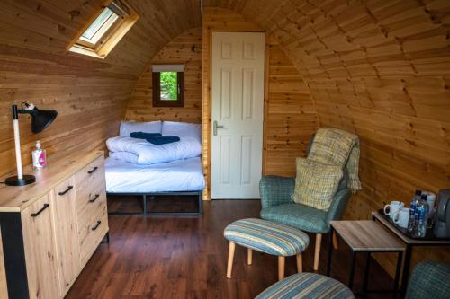 巴拉胡利什Glencoe Youth Hostel的小屋内带床和椅子的房间
