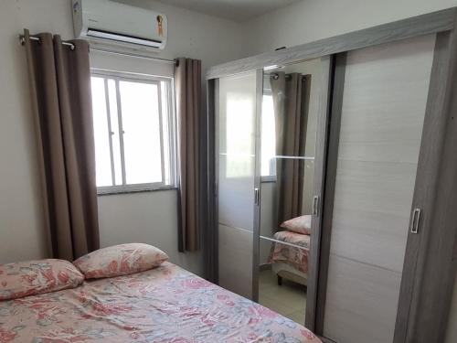 萨尔瓦多Apartamento Vila Aconchego Vermelho的一间卧室设有一张床和一个滑动玻璃门