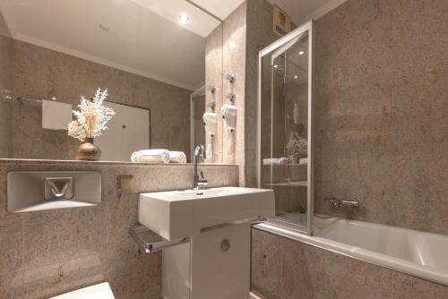 贝库姆Dreams Beckum的浴室配有盥洗盆、镜子和浴缸