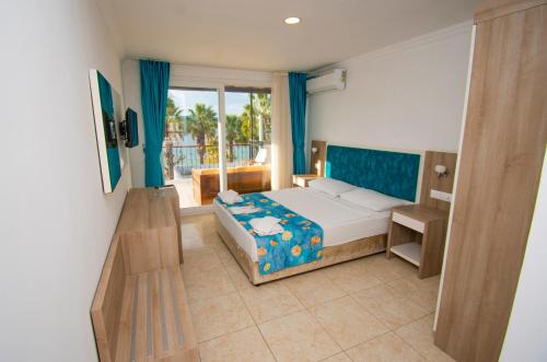 居姆贝特Sami Beach Hotel- All Inclusive的一间卧室设有一张床和一个阳台