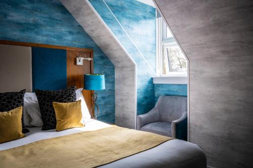 伊斯利昂塞道斯代尔别墅酒店的一间卧室设有一张床和蓝色的墙壁