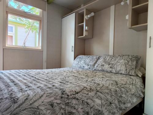 坎佩略伊尔加丁露营地的一间卧室设有一张床和一个窗口
