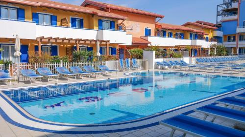 卡奥莱Villaggio Hemingway - Family Aparthotel的一座带蓝色椅子的酒店游泳池