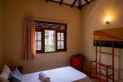 尼甘布The Tourist Balcony的一间卧室配有双层床和窗户。
