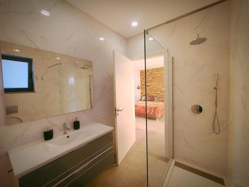 吉亚Villa Sunset的一间带水槽和玻璃淋浴的浴室