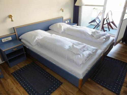 奥斯赛拜-屈隆斯博恩Yachthafenresidenz-Wohnung-8205-853的一张带白色床单和枕头的床