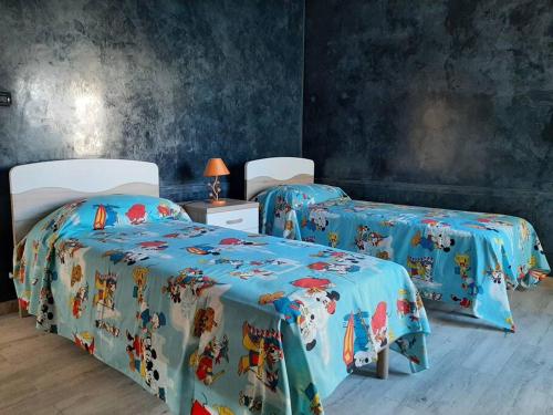 加拉蒂纳Casa Vacanza 30的蓝色墙壁客房中的两张单人床