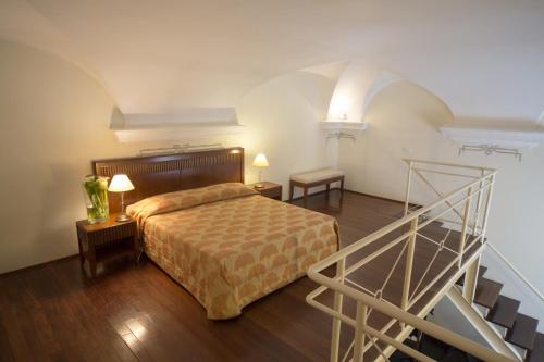 斯波托尔诺皇家别墅酒店的一间卧室配有一张床,房间设有楼梯