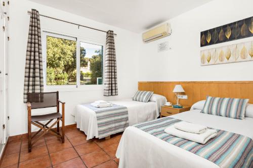 费雷列斯Villa Olives by Villa Plus的一间卧室设有两张床、一把椅子和一个窗户。