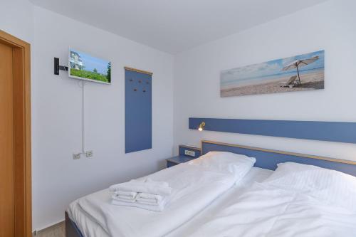 奥斯赛拜-屈隆斯博恩Yachthafenresidenz-Wohnung-5103-807的一间卧室配有一张床,上面有两条毛巾
