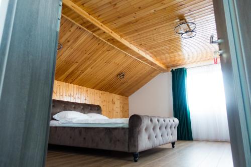 锡比乌EDA ROOMS的一间卧室设有一张床和木制天花板
