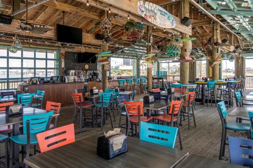 彭萨科拉海滩The Pensacola Beach Resort的用餐室配有桌子和五颜六色的椅子