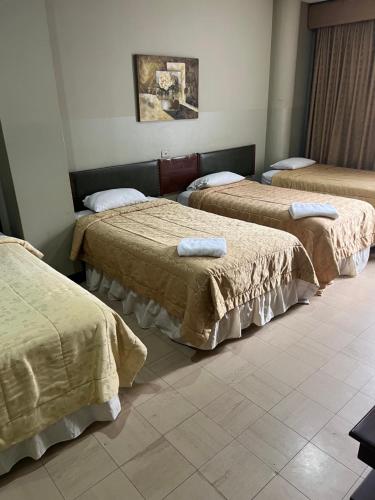 瓜亚基尔里佐酒店的一间设有三张床的客房,备有毛巾