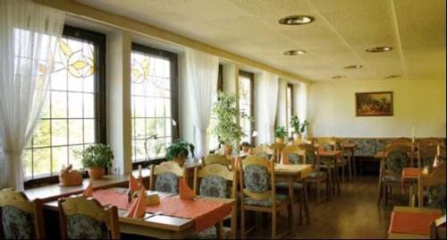 奥泊维森塔尔祖穆埃尔滕布劳豪斯酒店的用餐室设有桌椅和窗户。