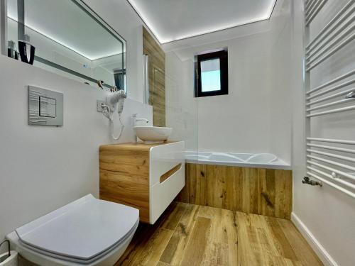 奥托佩尼Residence Odaile #1的浴室配有卫生间、盥洗盆和浴缸。