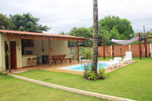 新艾朗Chalé Ubá的一个带游泳池和房子的后院