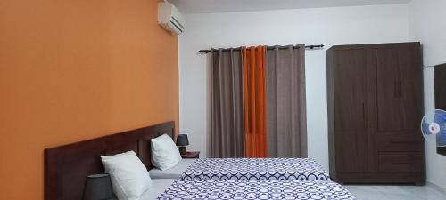 萨尔雷Ka-Bela 2的一间卧室配有床和橙色窗帘