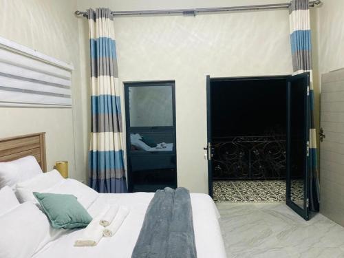 哈博罗内modern, two-story luxury house的一间卧室设有一张床和一个大型滑动玻璃门