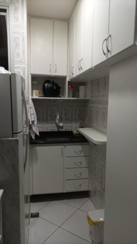 维多利亚Ap no melhor lugar do Centro com elevador, wi-fi e Smart TV的厨房配有白色橱柜、水槽和冰箱。