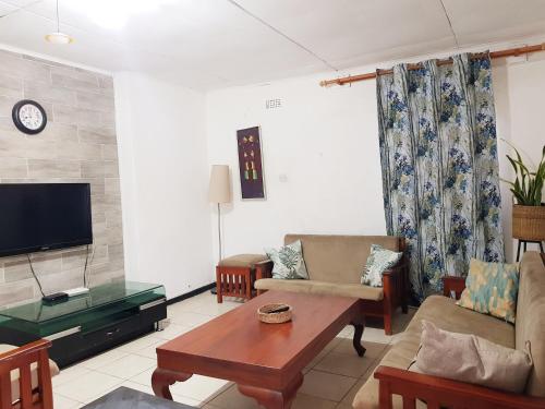 LimbeChinyonga Guesthouse的客厅配有沙发和桌子