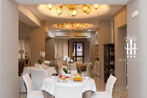 卡斯特拉玛雷帝斯达比亚Hotel Palma的用餐室配有白色的桌子和白色的椅子